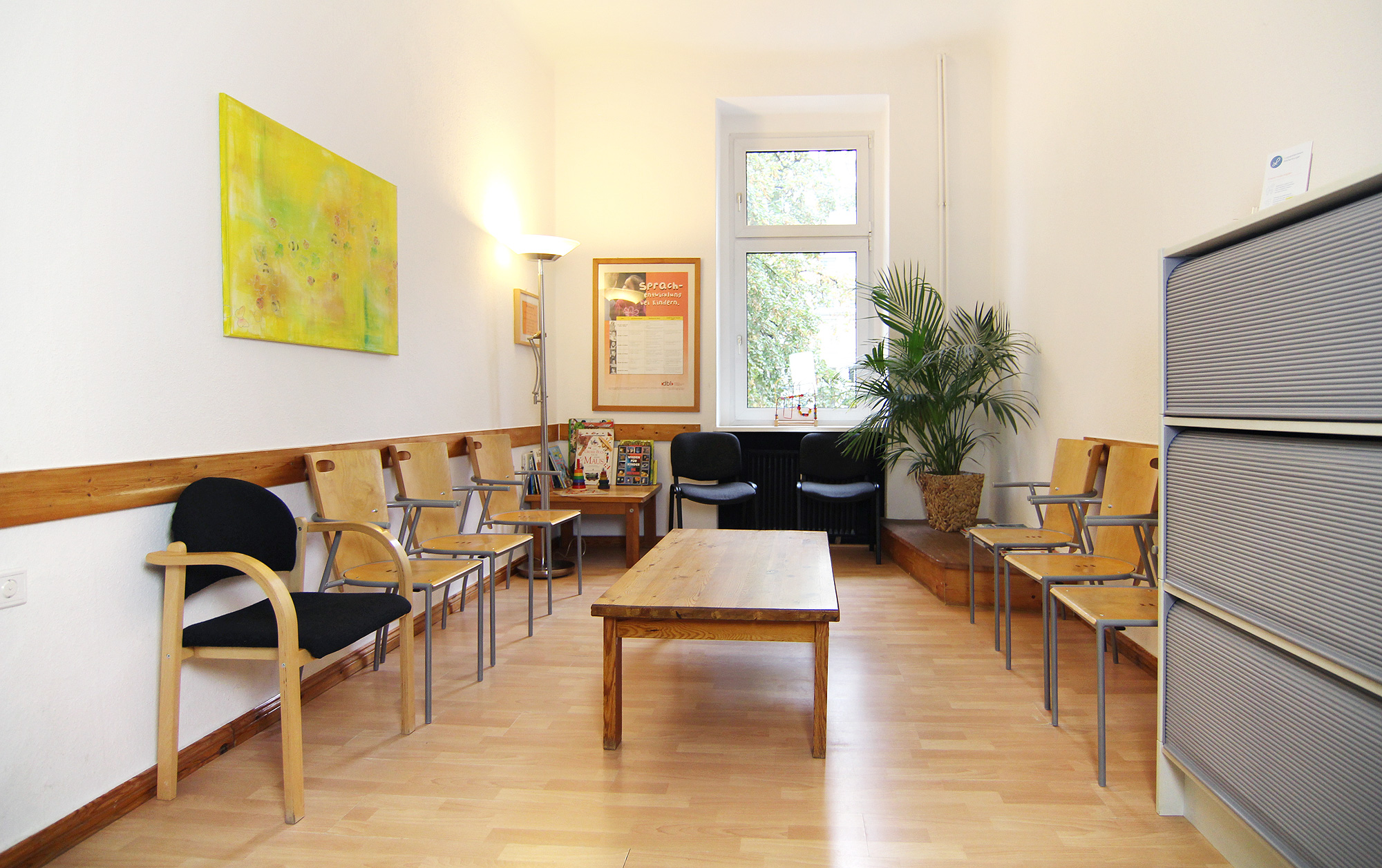 Helles Wartezimmer der Logopädie-Praxis in Berlin-Spandau mit Sitzplätzen, Kinderbüchern und Spielecke